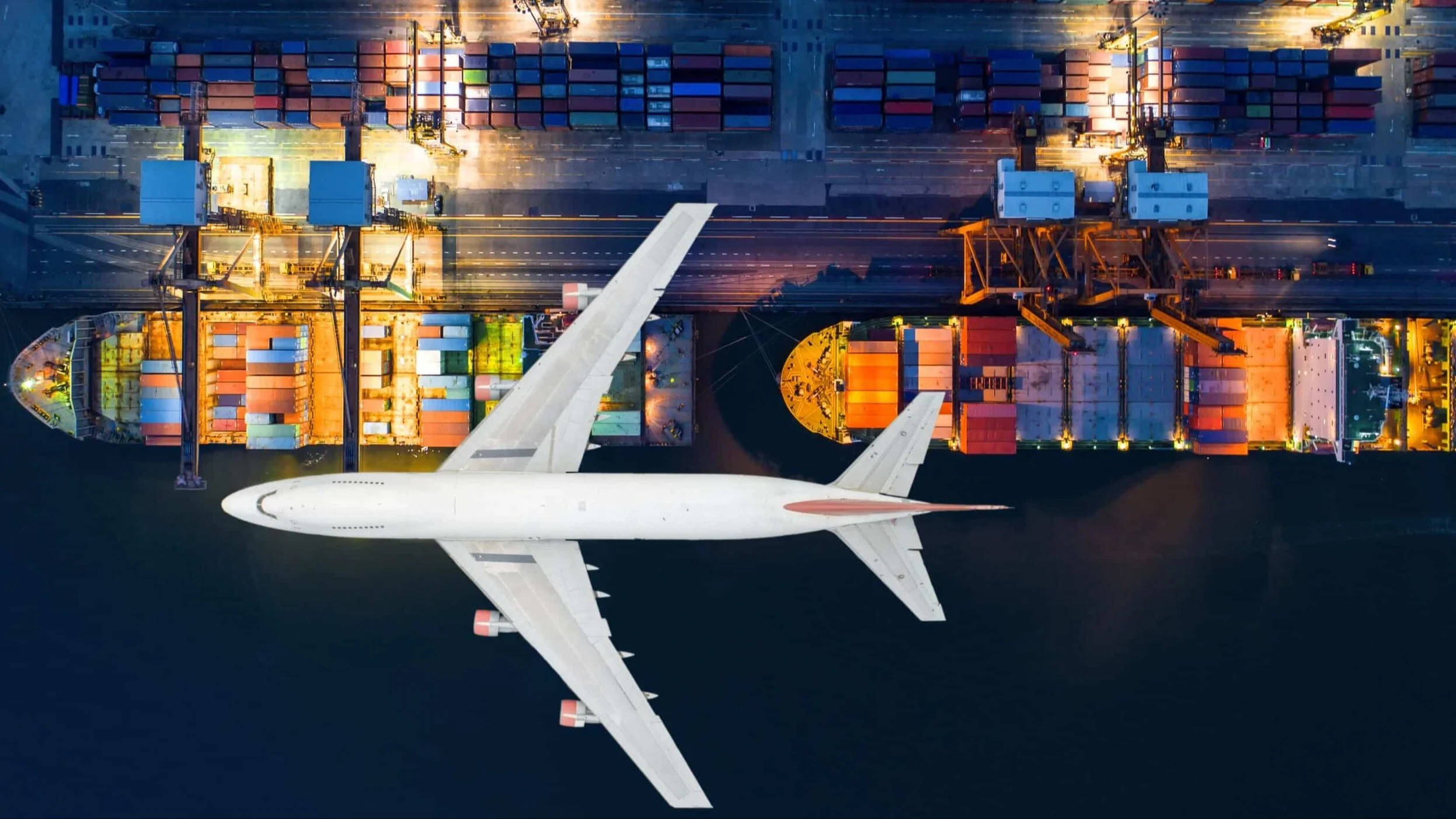 Air freight aircraft above shipping yard